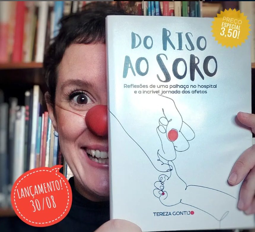 Palhaça Tereza mostra capa do livro riso ao soro. Na capa o desenho de uma mão adulta segurando uma mão de criança